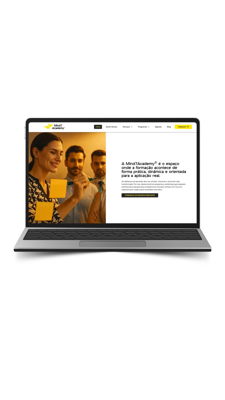 Laptop displaying MindTAcademy website homepage with three people holding yellow cup and Portuguese text describing the platform